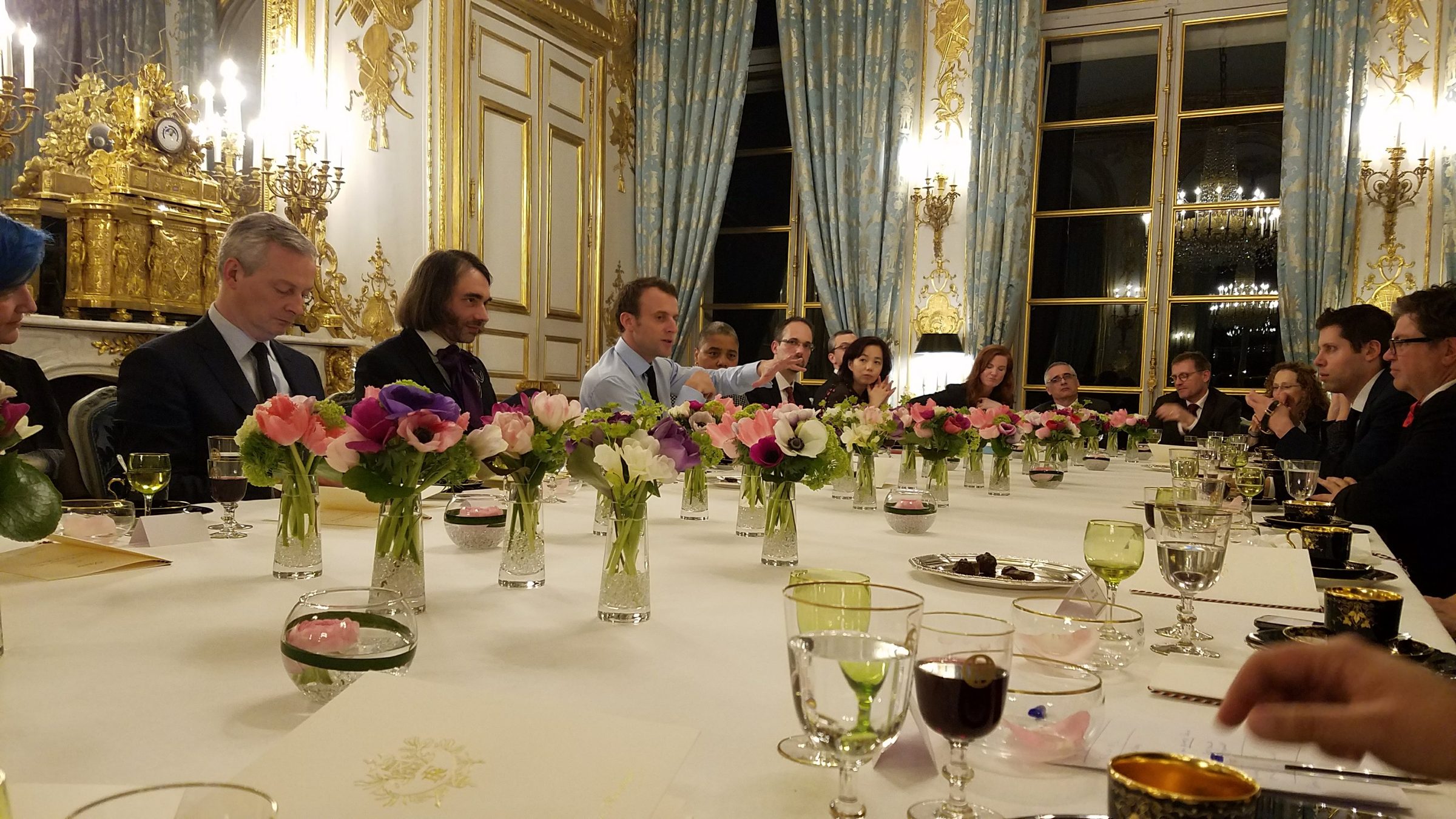 President Macron speaking at the dinner table with Bruno Le Maire, Cédric Villani and Sam Altman